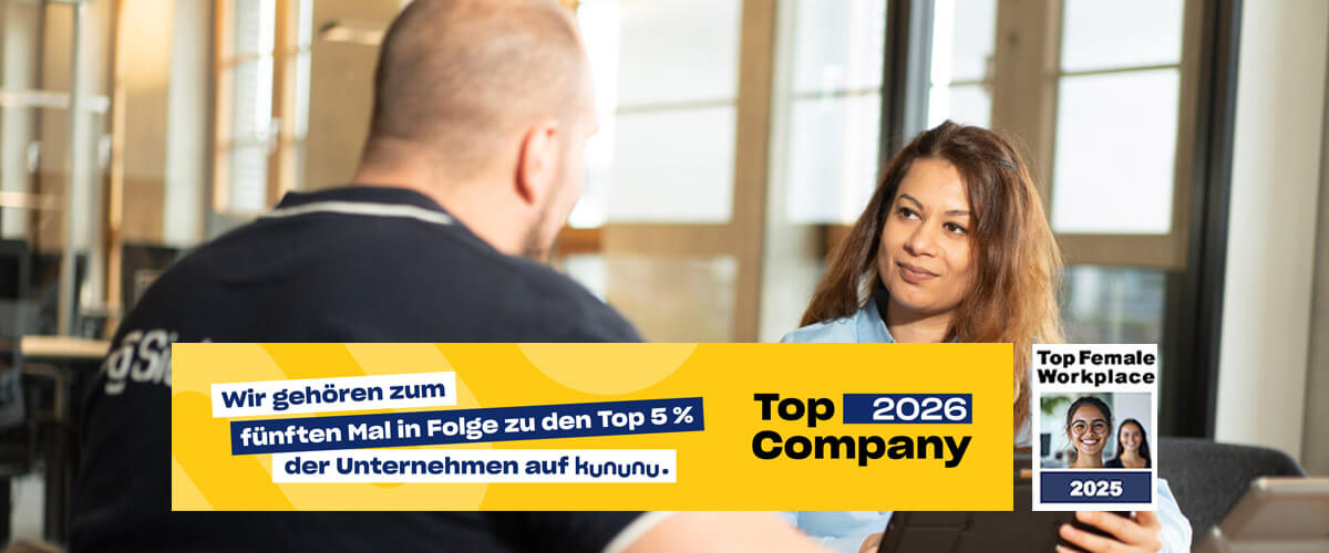 Mitarbeiter im Gespräch im Büro; eingeblendetes Kununu-Siegel „Top Company 2026“ und „Top Female Workplace 2025“.